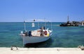 Small old white fishing boat in harbour, blue sea and sky. Royalty Free Stock Photo