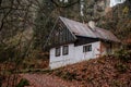 Small old white wooden house near village Mala Skala, moss roof, traditional hut or cottage surrounded by trees in autumn forest Royalty Free Stock Photo