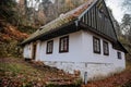 Small old white wooden house near village Mala Skala, moss roof, traditional hut or cottage surrounded by trees in autumn forest Royalty Free Stock Photo