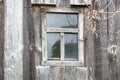 Small old window in a gray plank wall.Rugged handmade construction.Selective focus.Abandonment,reservation concept