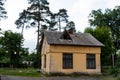 Small one-story house. Yellow building. Brick edifice near the pines. Old house with windows. Royalty Free Stock Photo