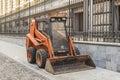 Small orange bulldozer machinery used for cleaning by municipality