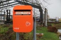 Small orange colored mailbox of PostNl at the countryside in the Netherlands