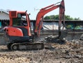 Small orange excavator or macro truck working in house construction site