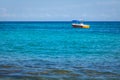 Small orange fishing boat, tourist boat in open water. Tropical turquoise blue sea background.