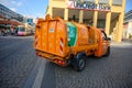 Small orange garbage truck on the cobbled streets of the old town district of Prague