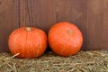 Small orange pumpkins on hay with wooden background Royalty Free Stock Photo