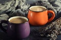 A small orange and purple mug with hot coffee. Near the dry lavender.