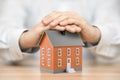 Small orange house covered by hands