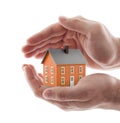 Small orange house protected by hands isolated on white