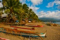 A small outrigger style Banca boat rests on a tropical beach.Pandan, Panay, Philippines. Royalty Free Stock Photo