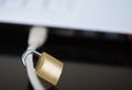 Small padlock locked around ethernet cable connected into side of laptop, internet security concept