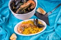 Small paella and big bowl with black mussel and shrimp in plate