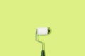 A small paint roller on a green background