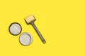 A small paint roller and a paint pot on a yellow background Royalty Free Stock Photo