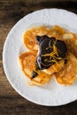 Small pancakes with chocolate glaze and candied orange Royalty Free Stock Photo