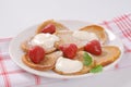 Small pancakes with cream and strawberries