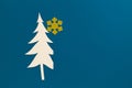 Small paper cut Christmas tree on blue background