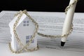 small paper house tied with chain