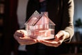 a small paper model house in the hand of a person Royalty Free Stock Photo