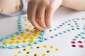 small parts in hands of child, girl plays with mosaic, fill in holes, fine motor skills Development, Early Learning Activities, Royalty Free Stock Photo