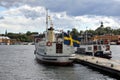 Small passenger boat docked in Stockholm harbor, flying the Flag of Sweden Royalty Free Stock Photo