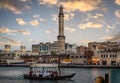 Small passenger boat passing in front of a Minaret in the Deira area of Dubai in the UAE