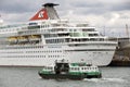 Small passenger ferry alongside cruise ship