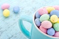 Small pastel easter eggs in a blue cup