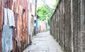 Small path into an alley in Bangkok, Thailand, left side is rust