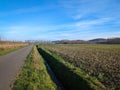 A small paved road, a majestic aqueduct and farmland under the glow of the sun