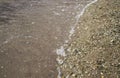 Small pebbles and wet sand on the sea beach; water line. Royalty Free Stock Photo
