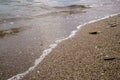 Small pebbles and wet sand on the sea beach; water line. Royalty Free Stock Photo