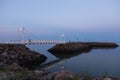 Small pedestrian bridge and jetty seen on the St. Lawrence river during a summer blue hour evening Royalty Free Stock Photo