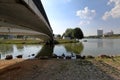 Small pedestrian concrete bridge over a narrow city river Royalty Free Stock Photo