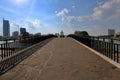 Small pedestrian concrete bridge over a narrow city river Royalty Free Stock Photo