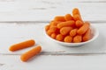 Small peeled pieces of carrot on white wooden table Royalty Free Stock Photo