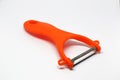 Small peeler with red plastic handle  on white background Royalty Free Stock Photo