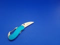 A small penknife with a sky blue handle that looks like it\'s starting to break