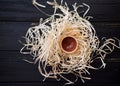 Small piala in straw nest on black desk