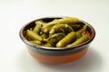 Small pickled cucumbers in brine according to a traditional recipe, served in a ceramic bowl Royalty Free Stock Photo