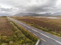 Small asphalt road in Connemara into mountains. Aerial view.