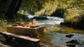 A small picnic table by a clear stream with fresh sandwiches and Royalty Free Stock Photo