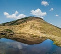 Small picturesque lake with clouds reflections at the Strymba Mount. Beautiful autumn day in Carpathian Mountains near Kolochava Royalty Free Stock Photo