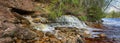 A small, picturesque waterfall by the river Royalty Free Stock Photo