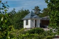 Small picturesque white outhouse connected to a house..