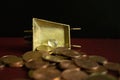 A small piece of clear crystal gemstone on a heap of money gold coins.