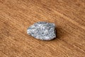 Small piece of the hardest kind of granite bed rock with its typical texture and color on wooden underground Royalty Free Stock Photo