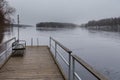Small pier at beach on Lake Ruotsalainen at cloudy, winter day, Finland. Royalty Free Stock Photo