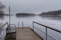 Small pier at beach on Lake Ruotsalainen at cloudy, winter day, Finland. Royalty Free Stock Photo